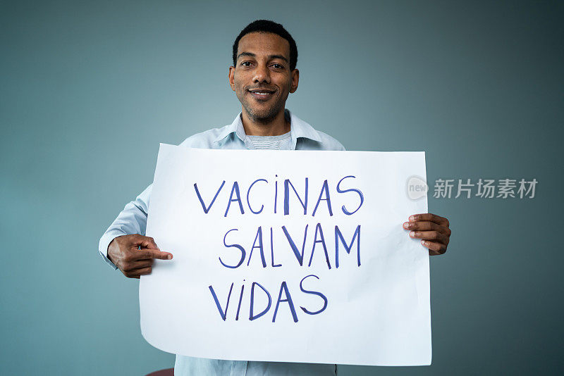 一个成熟的男子手持写着“vacinas salvam vidas”的横幅在工作室拍摄的肖像